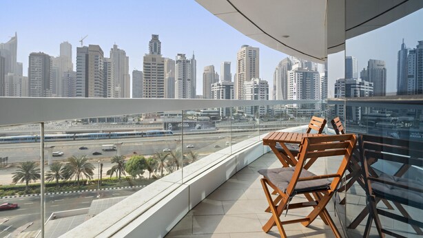 A balcony with a view of a cityscape, featuring modern buildings and a busy road. - Spacious 2 BD in JLT with Marina Views (Dubai)