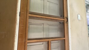 A double door with a wooden frame, a number '2' on the upper door, and a wall-mounted light fixture. - Villas Velarde: Studio in downtown Cozumel with pool (San Miguel de Cozumel)