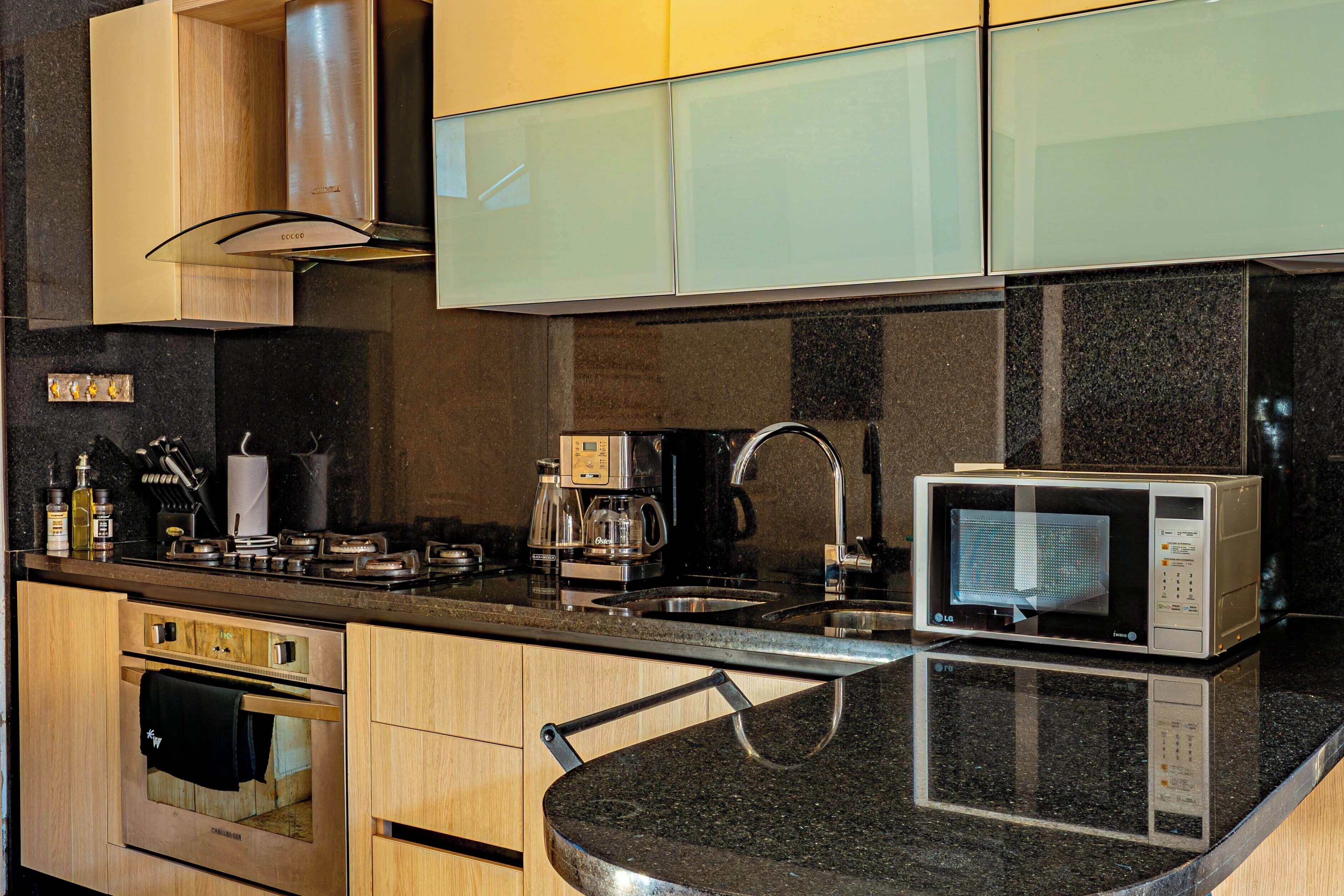 A kitchen with a microwave, coffee maker, and oven.