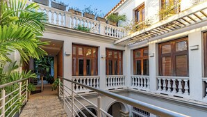 A multi-level building with balconies, a staircase, and a railing. - Wynwood Casa Santisimo in Cartagena (Cartagena)