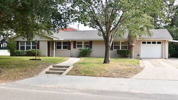 A single-story house with a front yard, a driveway, and a garage.