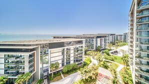 A modern residential complex with multiple high-rise buildings, featuring balconies, large windows, and a landscaped area with palm trees. - Sparkling Balcony Sea View Apt in Bluewaters (Dubai)