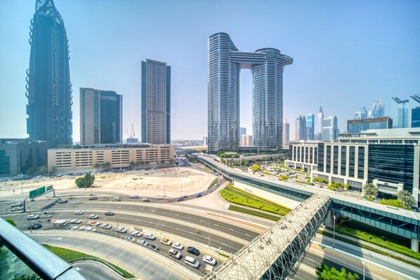 A cityscape with modern high-rise buildings, a highway, and a bridge.