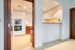 A modern kitchen with white cabinets, a microwave, and an oven.