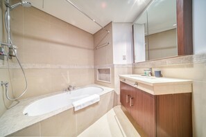 A modern bathroom with a freestanding bathtub, a vanity with a mirror, and a shower area.