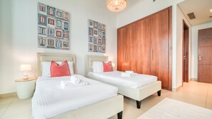 Ein Hotelzimmer mit zwei Betten, einem großen Holzschrank und zwei Wandbildern.