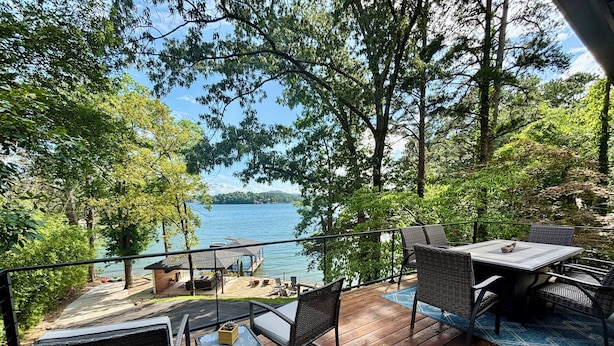 Une terrasse dotée de mobilier d’extérieur et offrant une vue sur un lac.