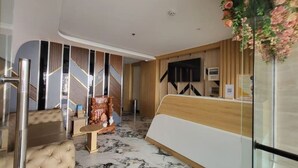 A modern hotel lobby with a reception desk, seating area, and a decorative wall. - Apartment 2 double bed, modern, new, Nha Trang (Nha Trang)