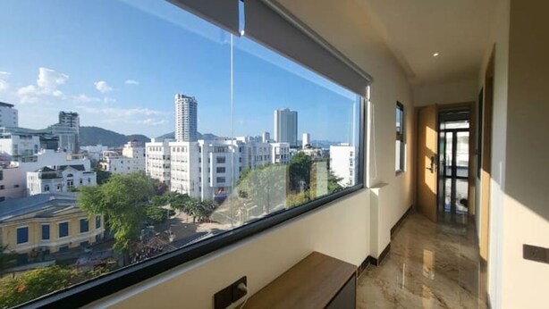 A modern hotel room with a large window offering a city view. - Apartment 2 double bed, modern, new, Nha Trang (Nha Trang)