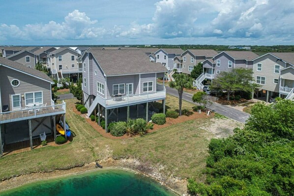 A coastal residential area with multiple two-story houses, a playground, and a clear view of the ocean.
