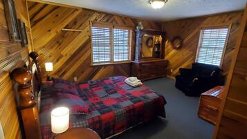 A cozy room with a bed, a dresser, a mirror, and two windows with blinds.