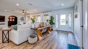 A modern living room with a sofa, wooden coffee table, and decorative plants. - ⚓Cortez Cabana! Canal front home w/heated pool & boat dock!⚓ (Bradenton)