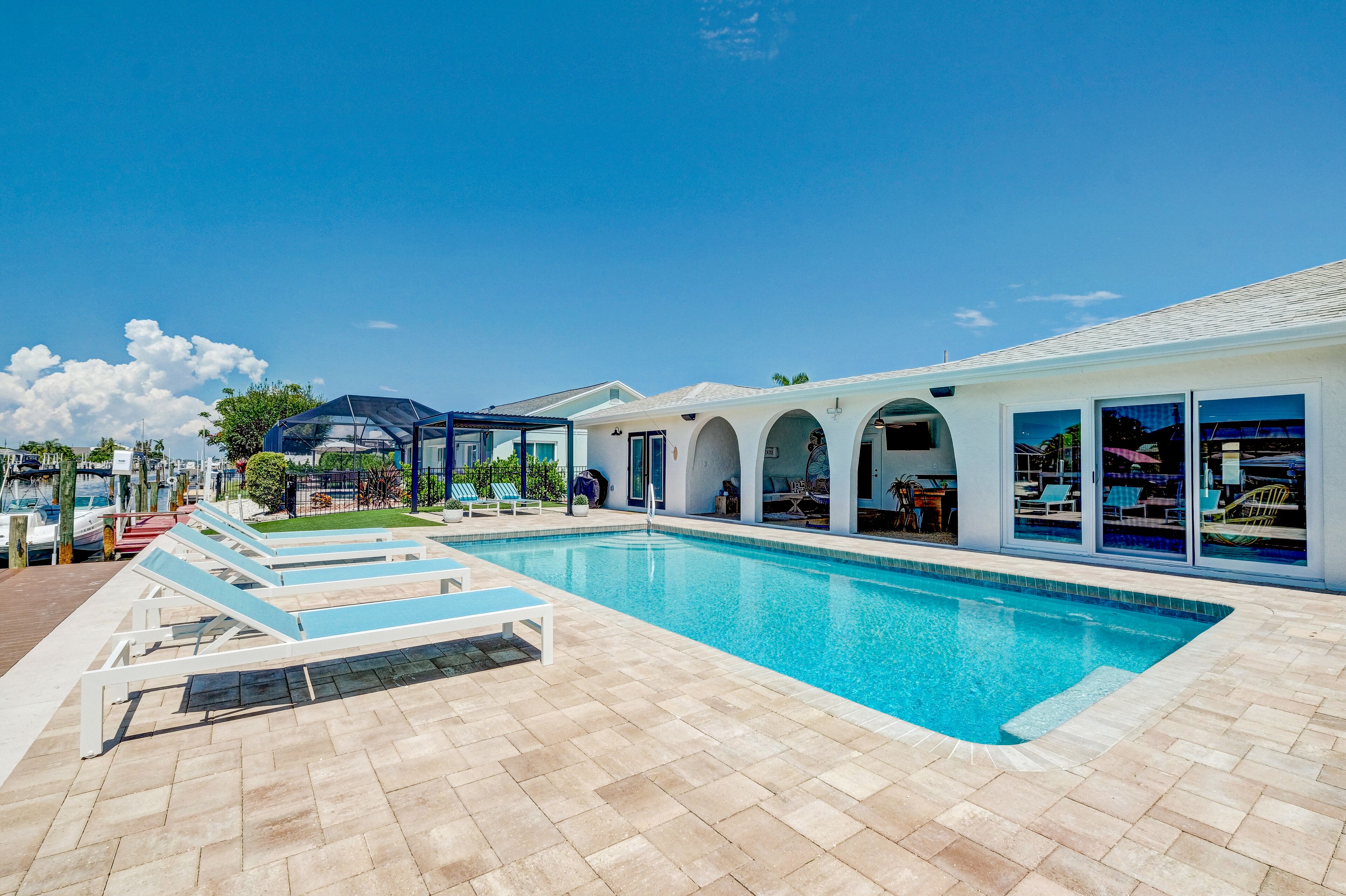 Una piscina con lettini e una zona coperta.