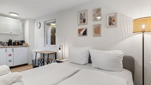 Una camera d'albergo con un letto, un comodino, una lampada e vista sulla cucina.