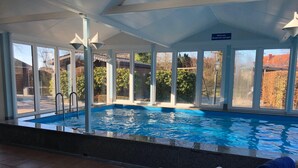An indoor swimming pool with clear glass walls, a tiled floor, and a bench with a towel. - "kleine Antje" im Herzen von Butjadingen - Alles Parat für die Perfekte Auszeit! (Butjadingen)