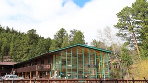 Un chalet doté d’une grande façade en verre, d’un balcon et d’une enseigne indiquant « Nickey’s Resort ».