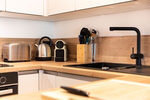 A modern kitchen with a stainless steel kettle, a toaster, and a sink with a black faucet. - Immodreams - Le Blue Velvet - Avoriaz (Avoriaz)