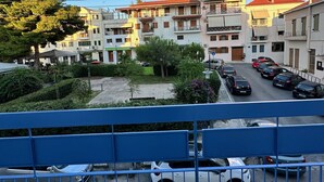 A residential area with multi-story buildings, a parking lot, and a blue railing in the foreground.