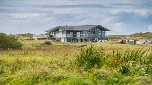 A modern two-story building with a flat roof, large windows, and a glass balcony. - Pen Y Parc Rhosneigr -  a coastal that sleeps 4 guests  in 2 bedrooms (Rhosneigr)