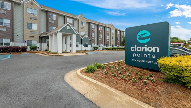A hotel entrance with a sign reading 'Clarion Pointe by Choice Hotels,' a driveway, and a parking lot. - Starkville Inn and Suites (Starkville)