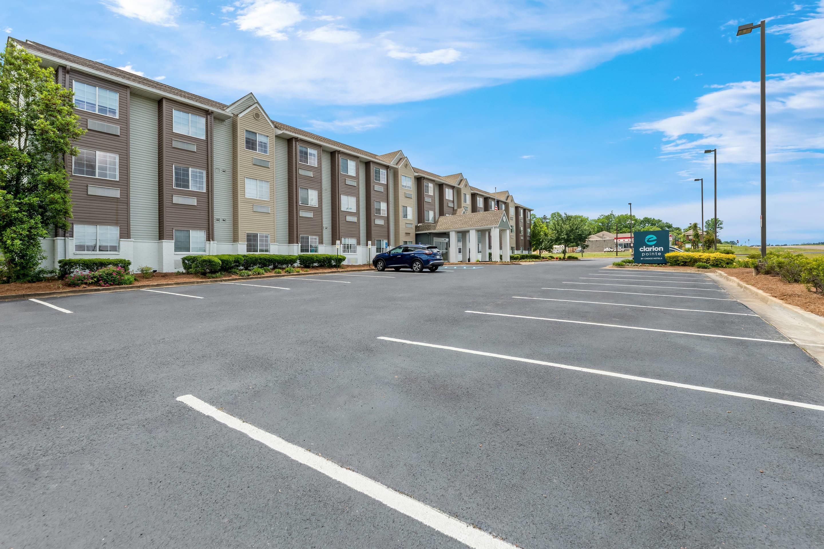 A multi-story hotel with a parking lot and a sign for 'Clarion Paint.'
