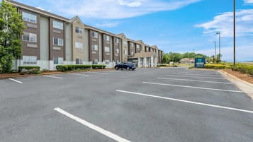 A multi-story hotel with a parking lot and a sign for 'Clarion Paint.'