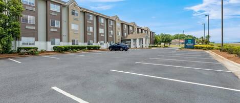 A multi-story hotel with a parking lot and a sign for 'Clarion Paint.'