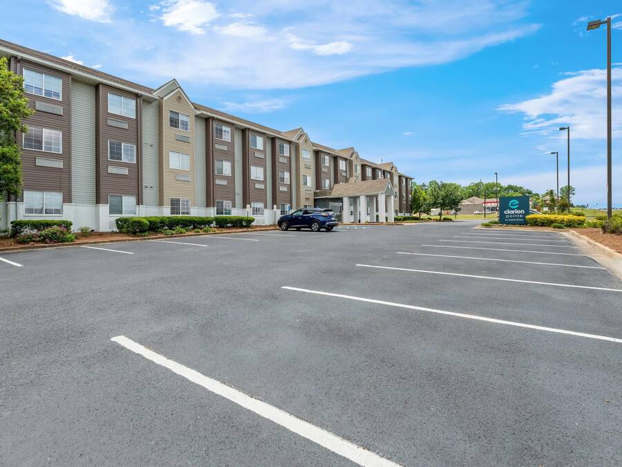 A multi-story hotel with a parking lot and a sign for 'Clarion Paint.'