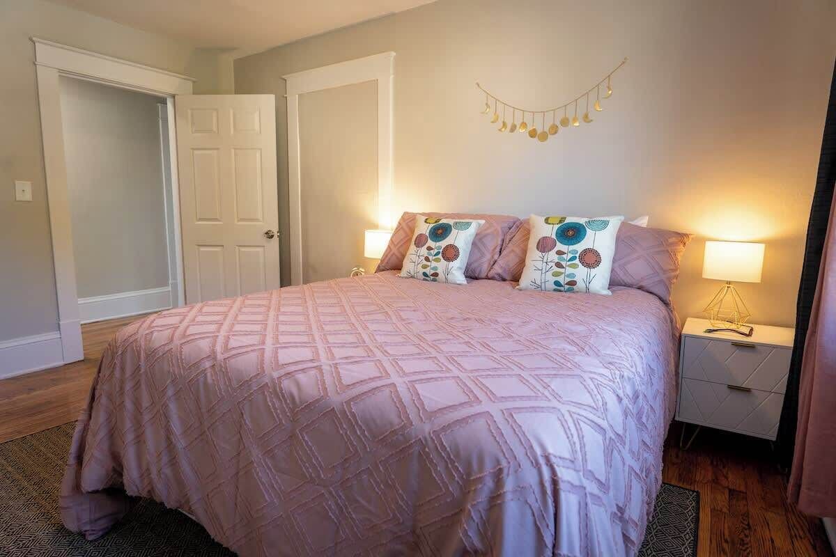 A bedroom with a large bed, two bedside tables, and a door.