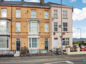 A row of terraced houses with bay windows, a 'sold' sign, and a 'give way' sign.