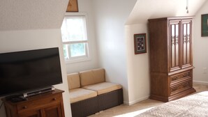 A bedroom with a large bed, a television on a wooden stand, a window, a ceiling fan, and a wooden cabinet. - A Bigger Catch Supply, NC ICW Best Fishing Hole In Brunswick County NC!!!! (Supply)