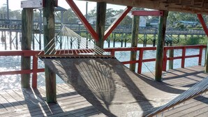 A wooden deck with a hammock and a view of a bridge over water. - A Bigger Catch Supply, NC ICW Best Fishing Hole In Brunswick County NC!!!! (Supply)
