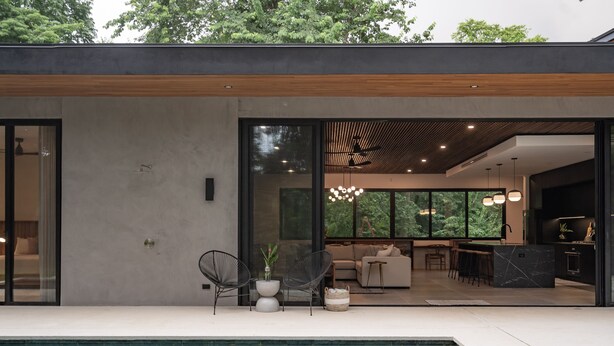 Ein modernes Haus mit Pool, Essbereich und Küche.
