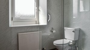 A bathroom with a toilet, a hand dryer, a radiator, and a window with a view of a field. - 3 bedroom accommodation in Castle Douglas (Castle Douglas)