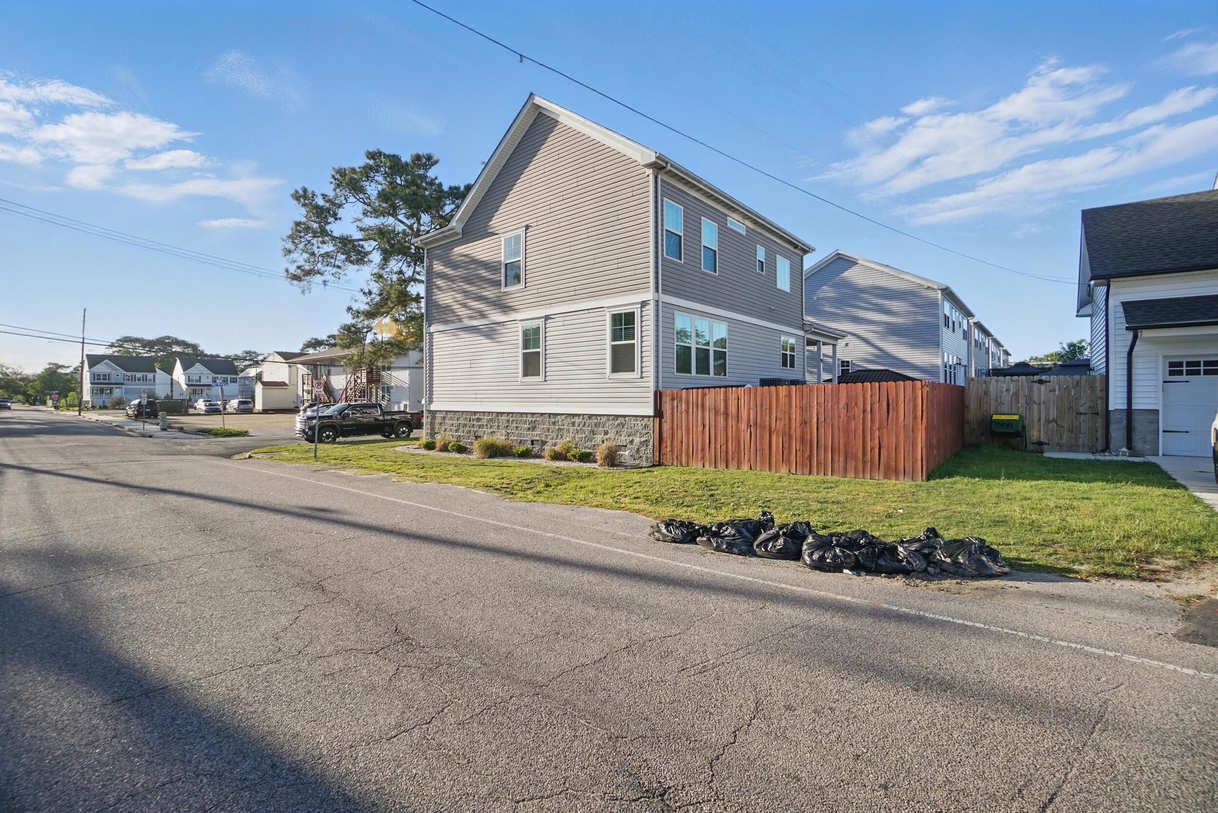 Une maison d’habitation à deux étages, dotée d’une clôture en bois, d’une allée et donnant sur la rue.