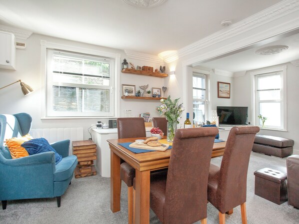 A dining area with a wooden table, chairs, and a blue armchair.