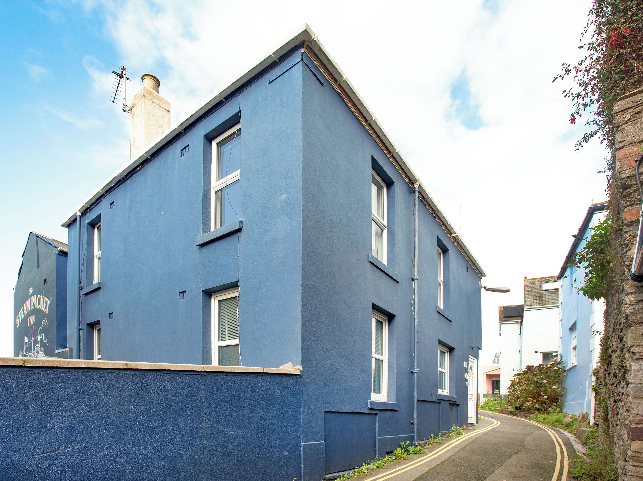 A two-story building with a flat roof, multiple windows, and a chimney.