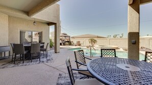 Un patio al aire libre con piscina, mesa y sillas.