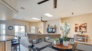 Amplia sala de estar con mesa de comedor, sillas, sofá y televisor.