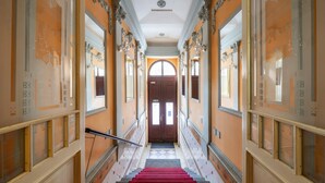 A grand hallway with a red carpet leading to a large arched doorway. - Hotel Raffaello Prague (Prague)