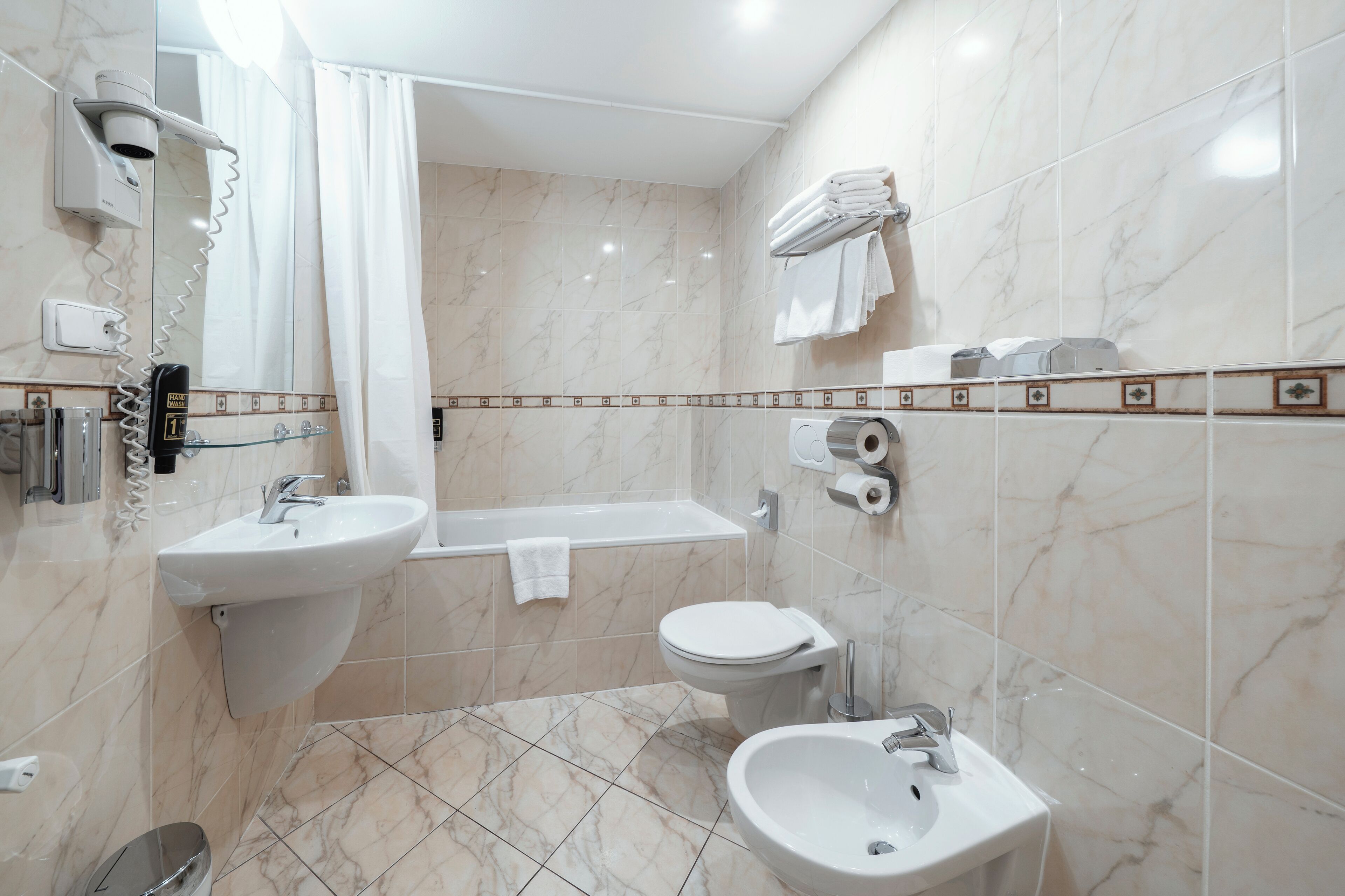 A modern bathroom with a sink, toilet, and bathtub.