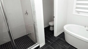 Ein Badezimmer mit Dusche, Toilette und Badewanne.