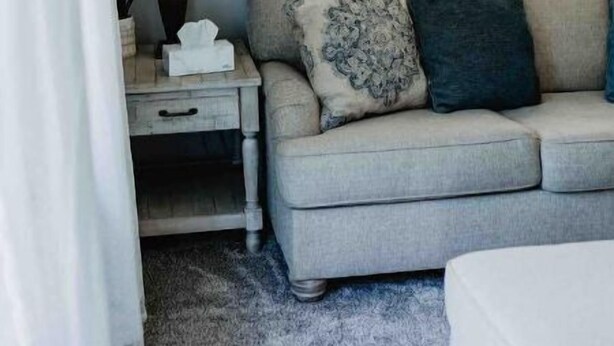 A cozy room with a grey sofa, a small bedside table with a lamp, and a window with curtains. - Rancher in Mont Alto (Mont Alto)