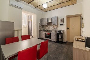 A compact kitchen with grey cabinets, a built-in oven, and a microwave.