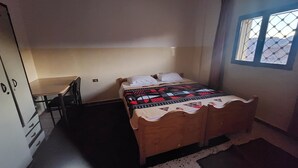 Una stanza piccola e modesta con un letto, una scrivania e una finestra.