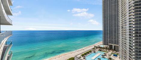A high-rise hotel with a pool and beach view.