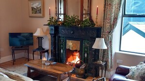 A cozy living room with a fireplace, a television, and a comfortable seating area.