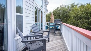 A wooden deck with Adirondack chairs, a table, and a railing. - Duck Location! Volleyball, Pool, Game Room & More (Duck)