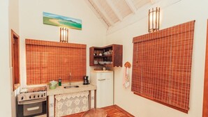 A compact kitchen with a stove, sink, and wooden cabinets. - Ibirawave (Imbituba)