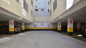 A multi-level parking garage with yellow and white pillars, clear directional signage, and a central open area. - Mar Doce Lar (Cabo Frio)